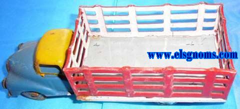 Camin fabricado en Portugal en hojalata embutida en prensa y troquelada. Cabina pintada en amarillo y cap en azul. Soporte (suelo) pintado en gris y caja troquelada en forma de reja pintada exterior en rojo e interior blanco. Frontal y ruedas con restos de estao.